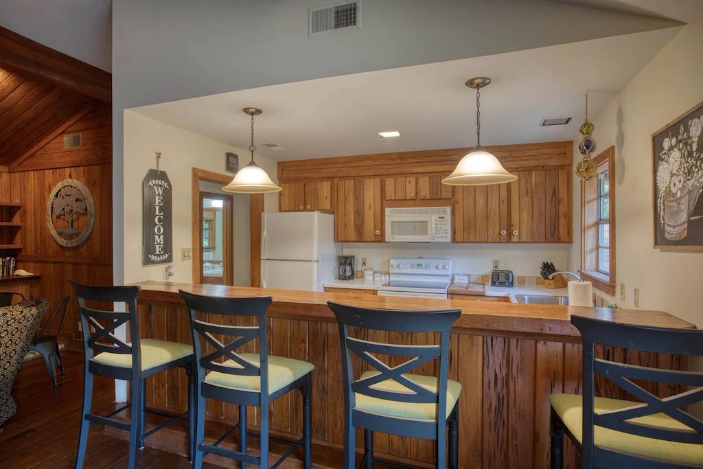 A kitchen with a bar and chairs in it
