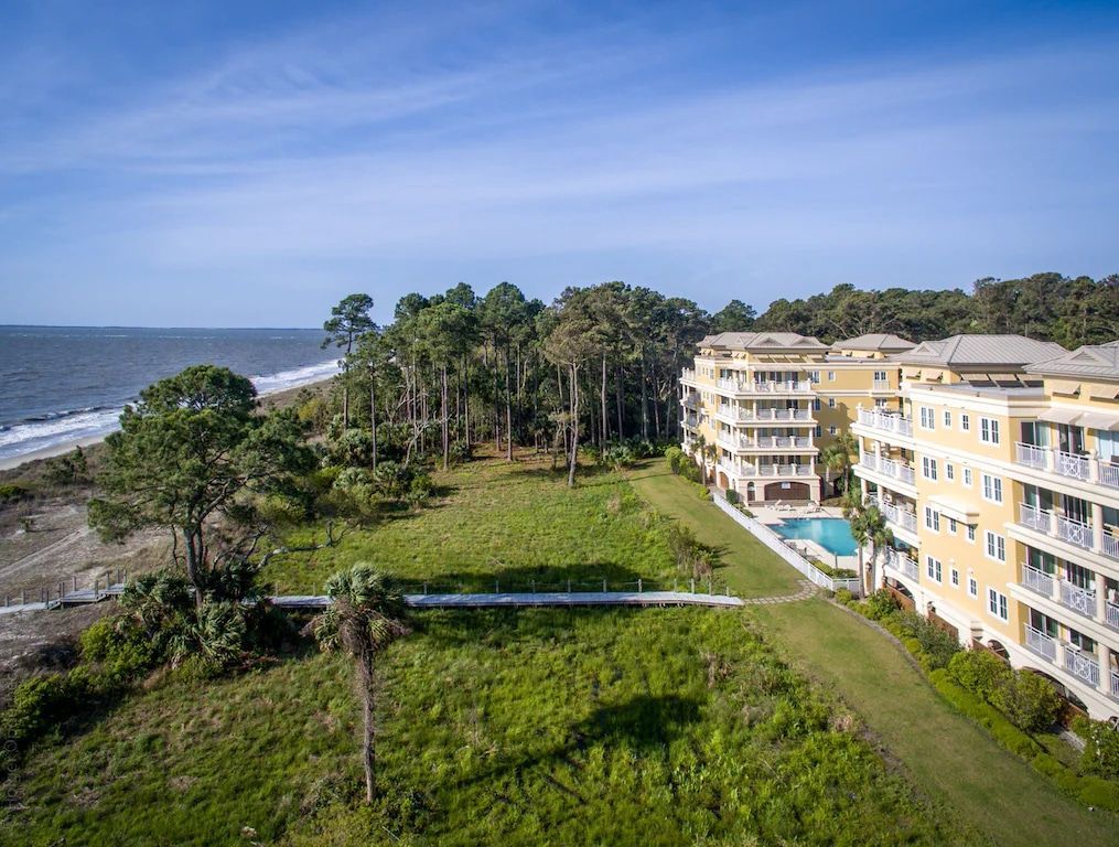 An aerial view of a large apartment building next to the ocean.
