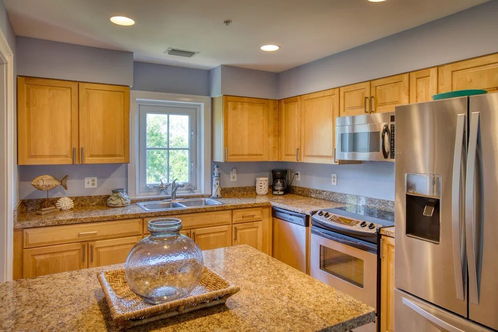 A kitchen with stainless steel appliances and granite counter tops.