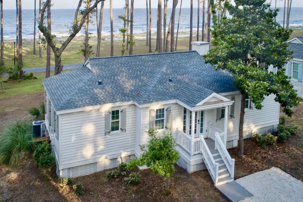 An aerial view of a white house with a blue roof