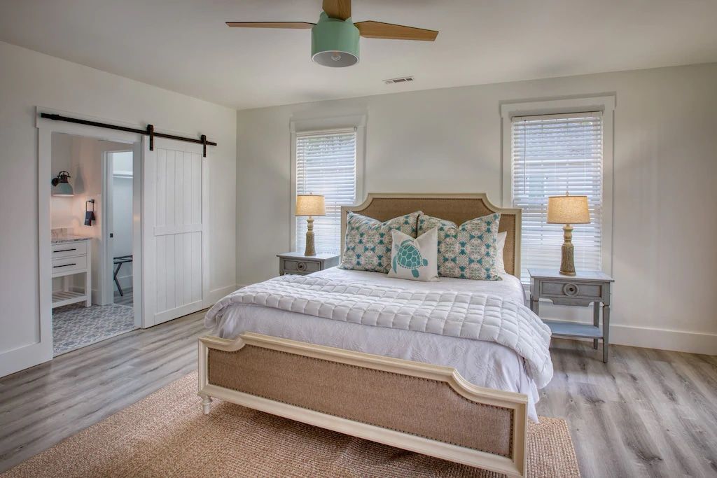 A bedroom with a king size bed and a ceiling fan.