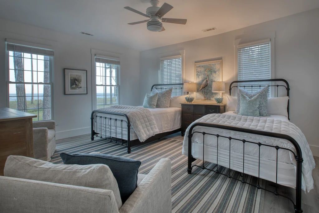 A bedroom with two beds , a couch , and a ceiling fan.