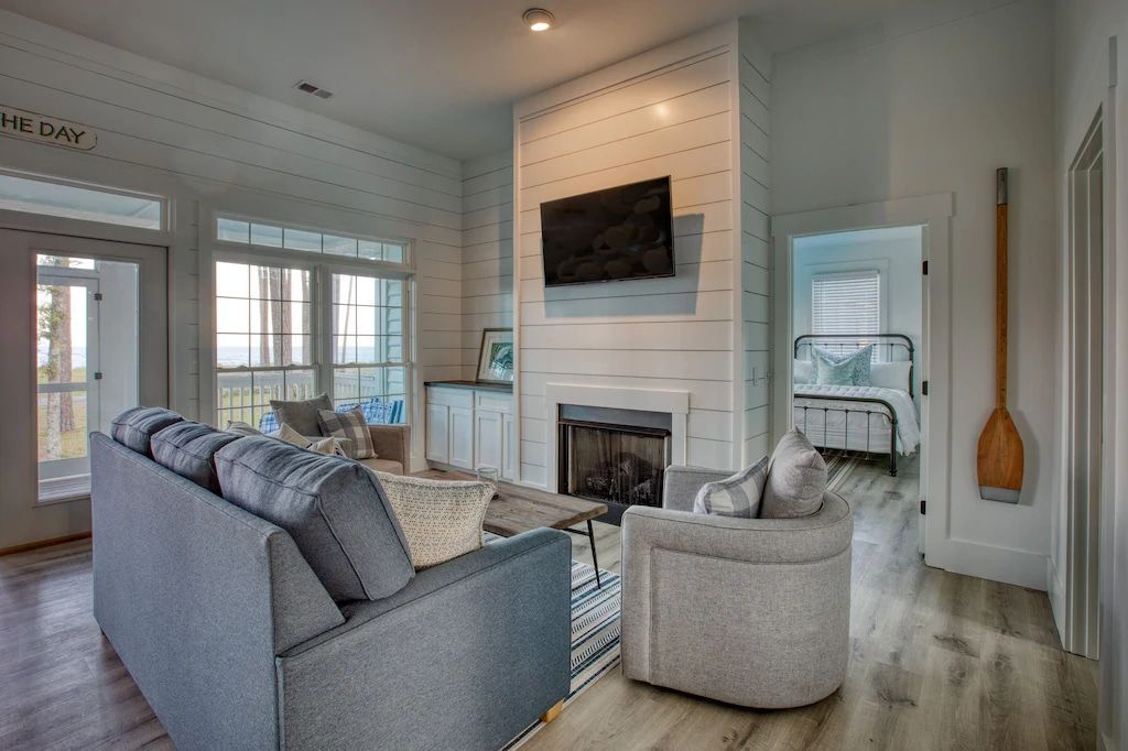 A living room with a couch , chair , fireplace and television.