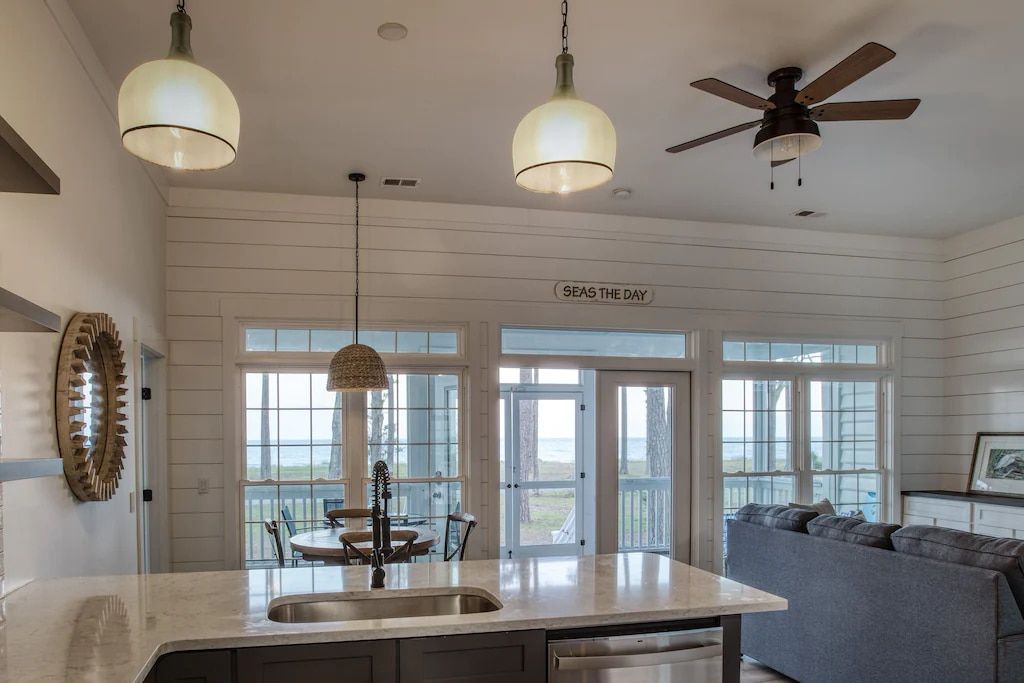 A kitchen with a sink and a ceiling fan
