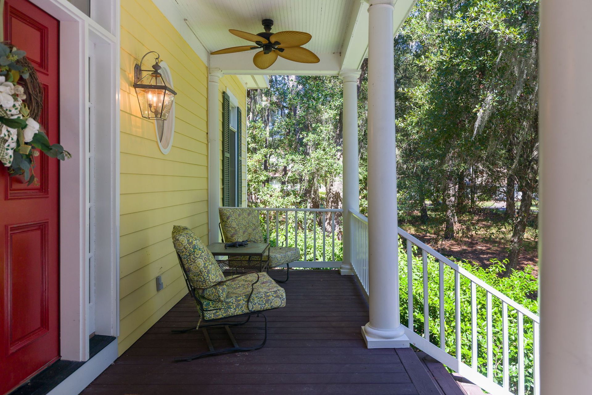 A hallway with a table and a lamp in front of a door.