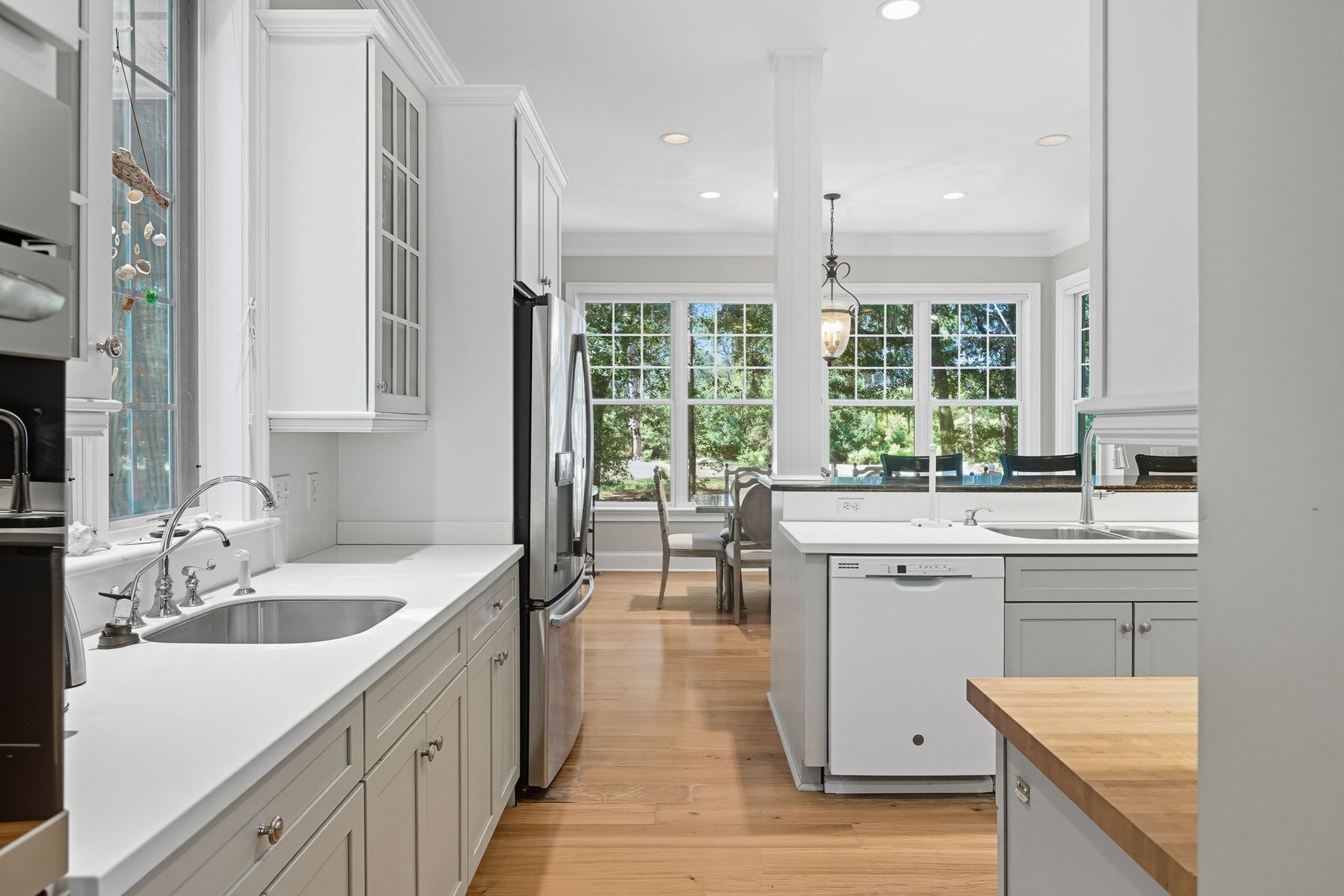 A bathroom with white tiles and a sliding glass shower door.