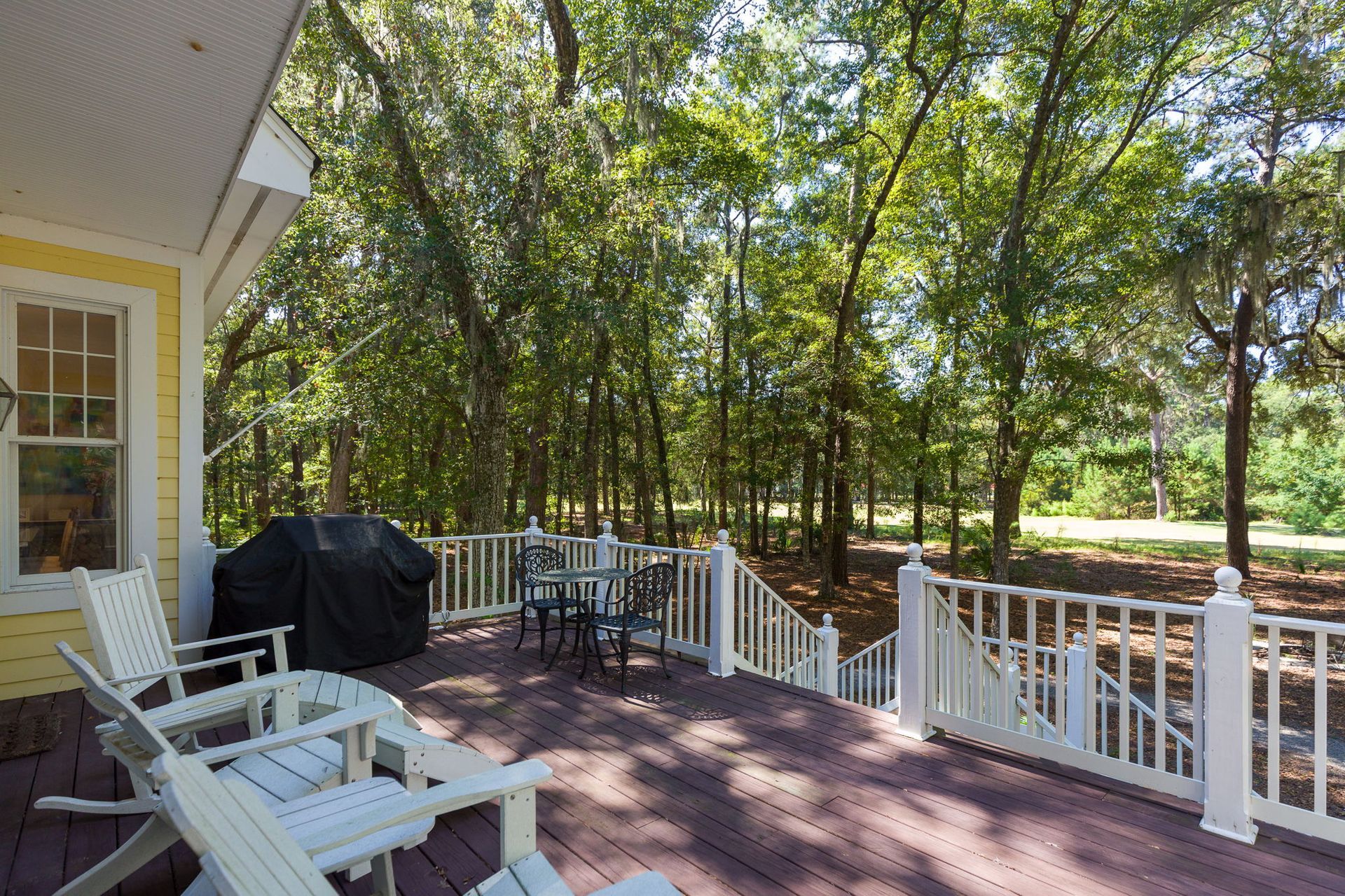 A screened in porch with a view of trees and the ocean