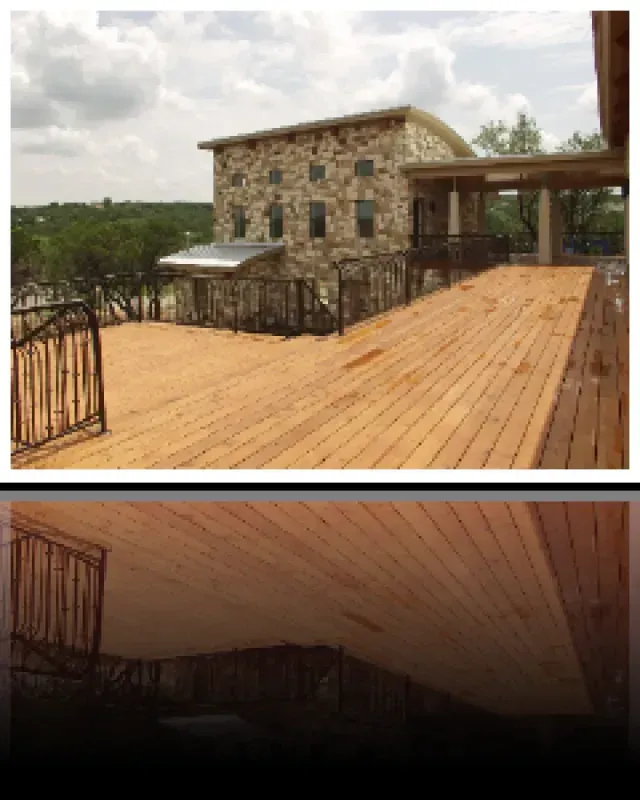 A wooden deck with a stone building in the background