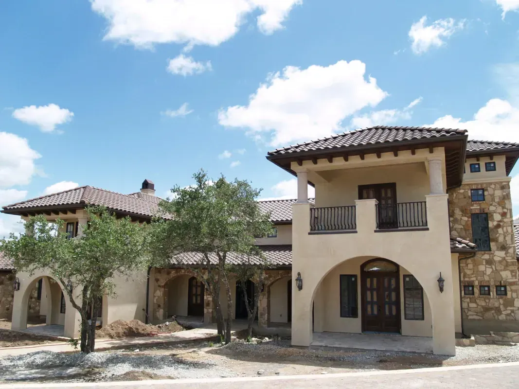 A large house with a balcony and trees in front of it