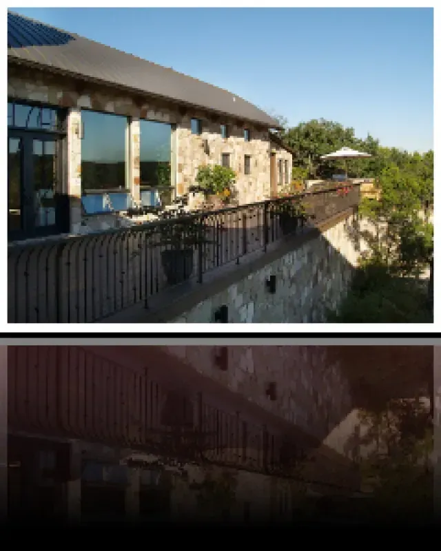 A picture of a building with a balcony and trees in the background