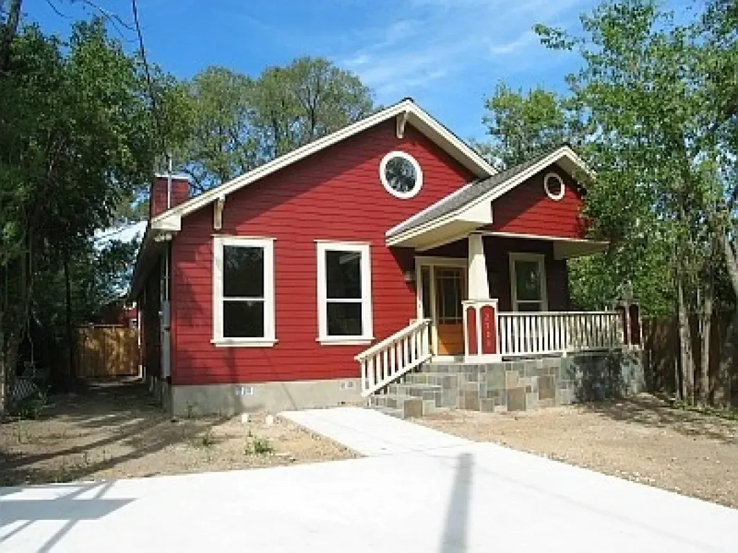 A red house with white trim and a circular window