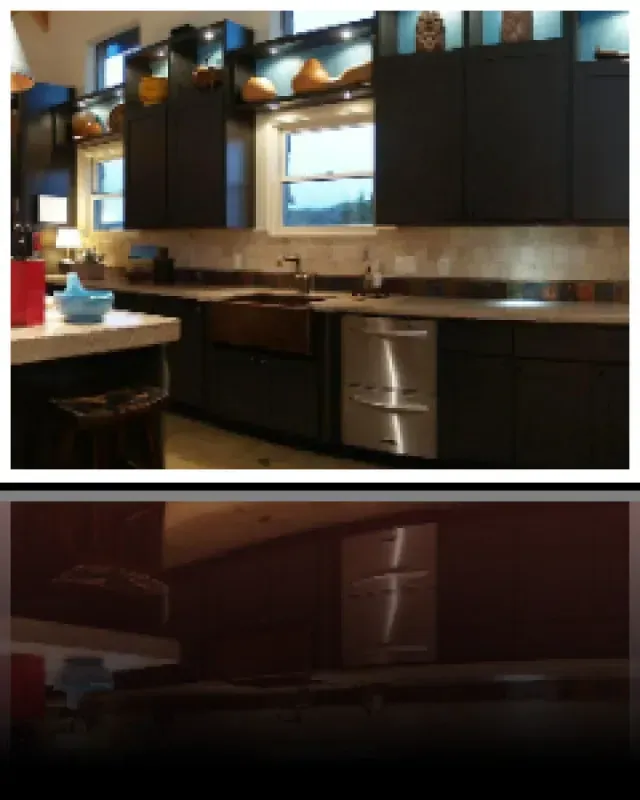 A kitchen with black cabinets and stainless steel appliances
