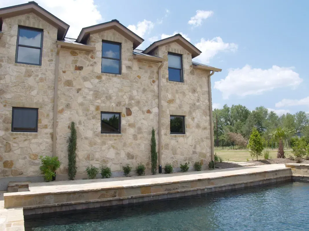 A large stone building with a swimming pool in front of it