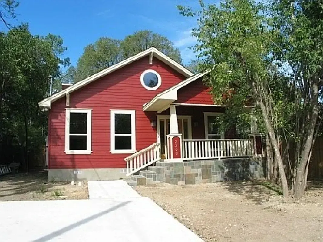 A red house with a white porch and stairs