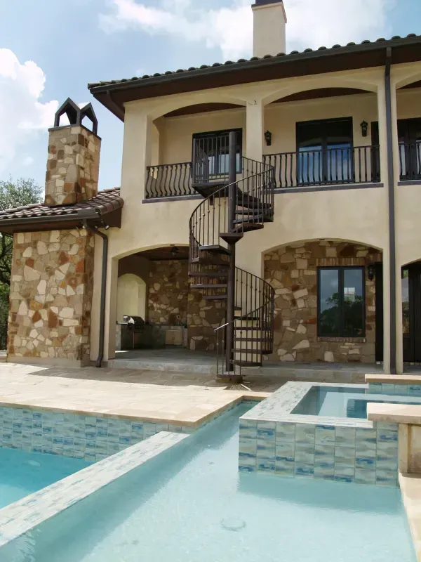 A large house with a spiral staircase and a swimming pool
