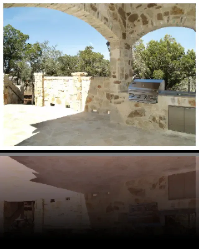 A picture of a stone archway with trees in the background