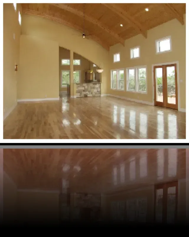 A large empty room with hardwood floors and lots of windows