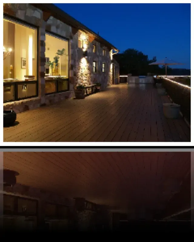 A picture of a house at night with a wooden deck