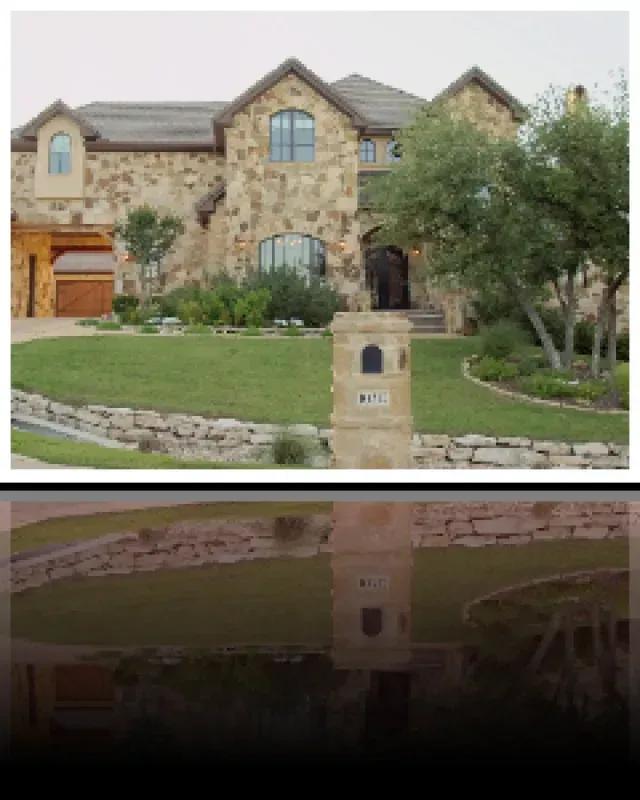 A large stone house with a mailbox in front of it