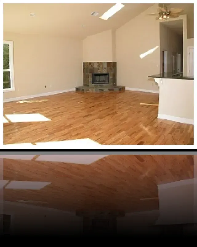 An empty living room with hardwood floors and a fireplace
