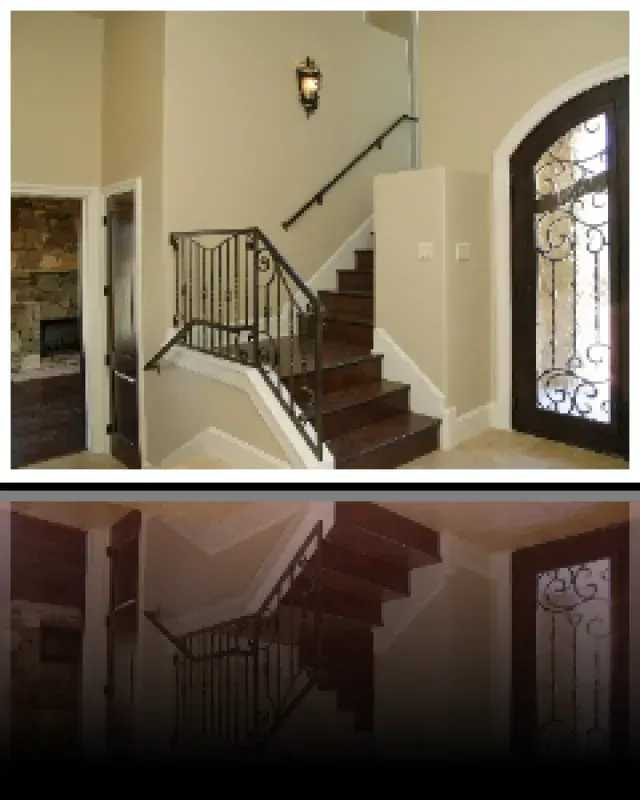 A picture of a staircase with a wrought iron railing