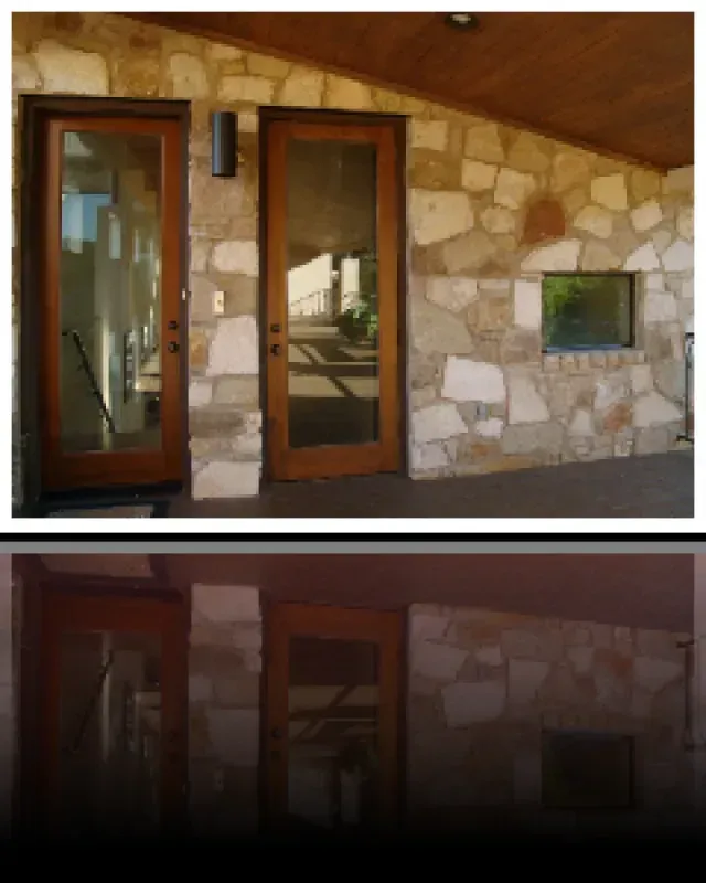 A picture of a stone building with sliding glass doors