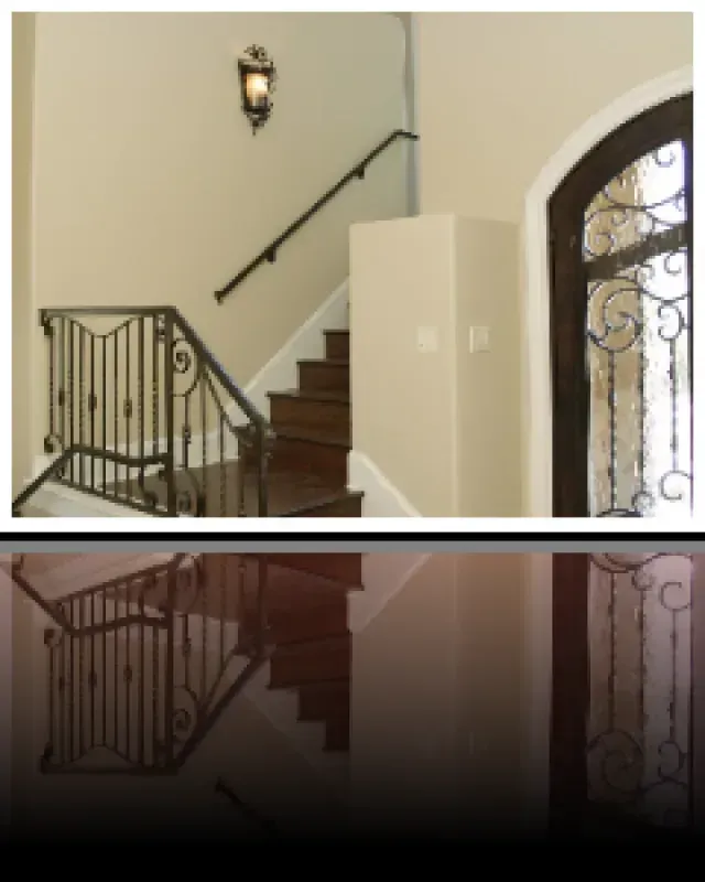 A picture of a staircase with a wrought iron railing