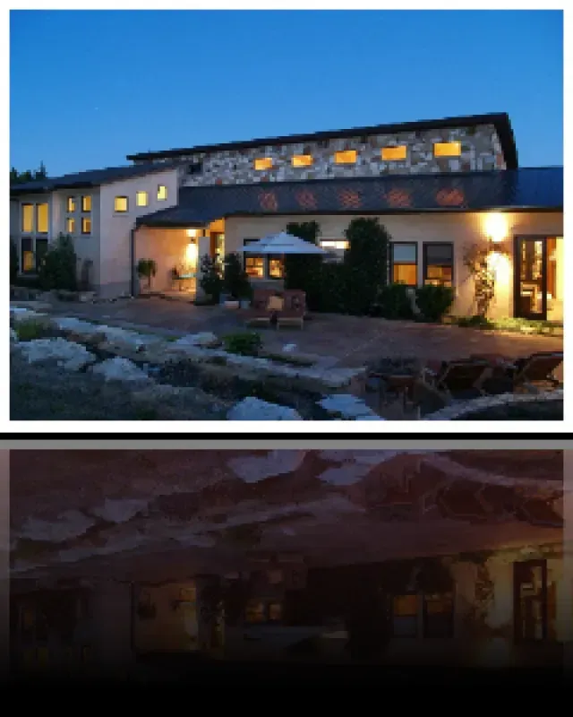 A house with a lot of windows is lit up at night