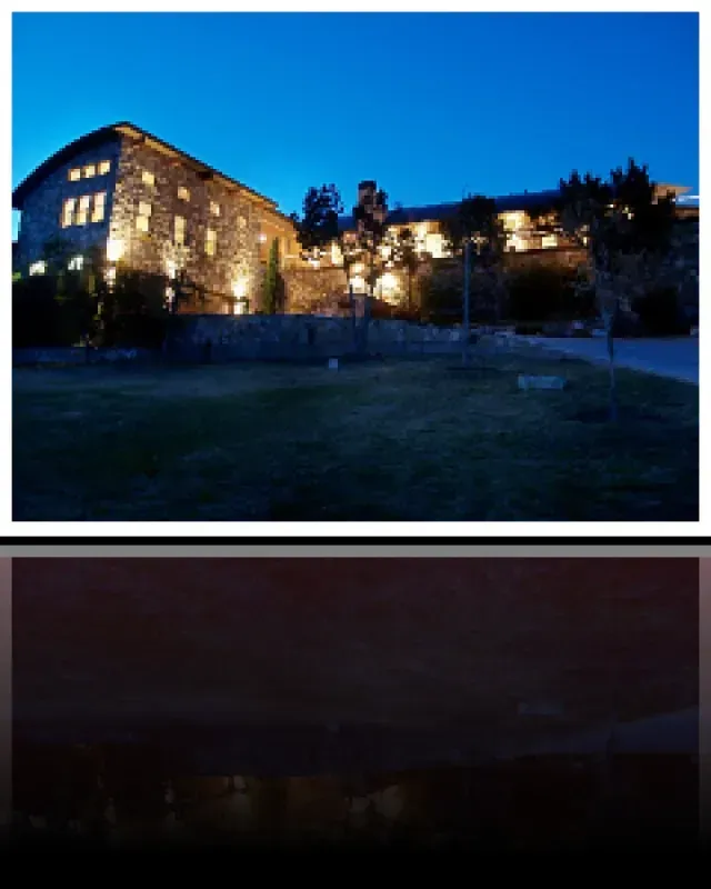 A large stone building is lit up at night