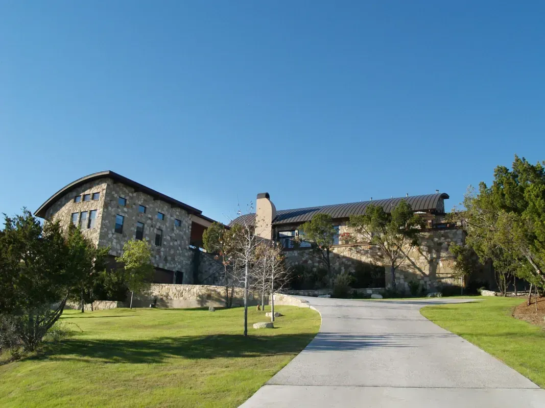 A large stone building with a driveway leading to it.