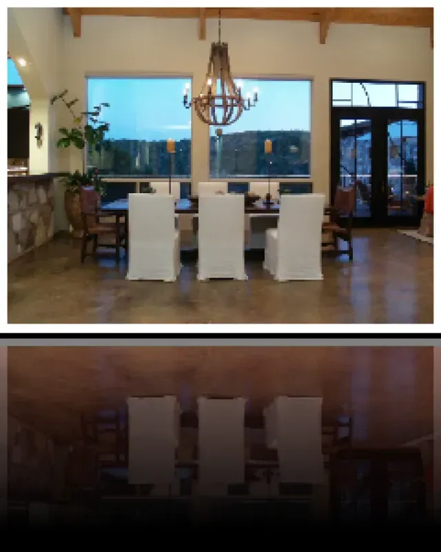 A dining room with white chairs and a chandelier