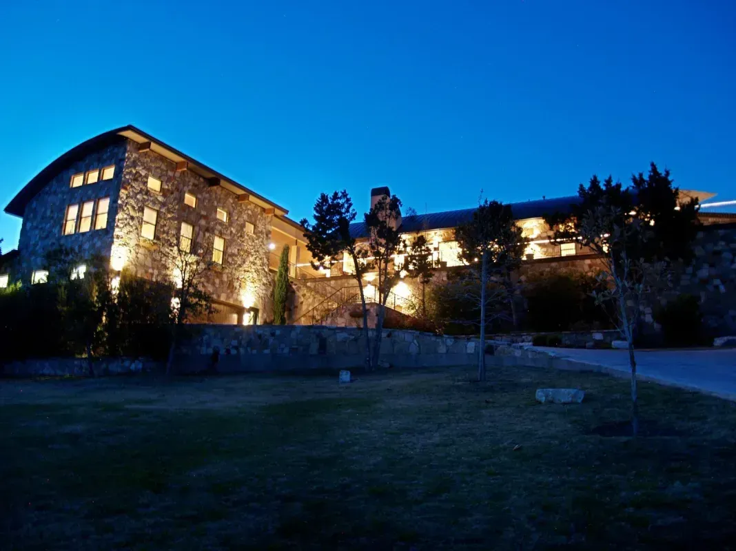A large stone building is lit up at night.