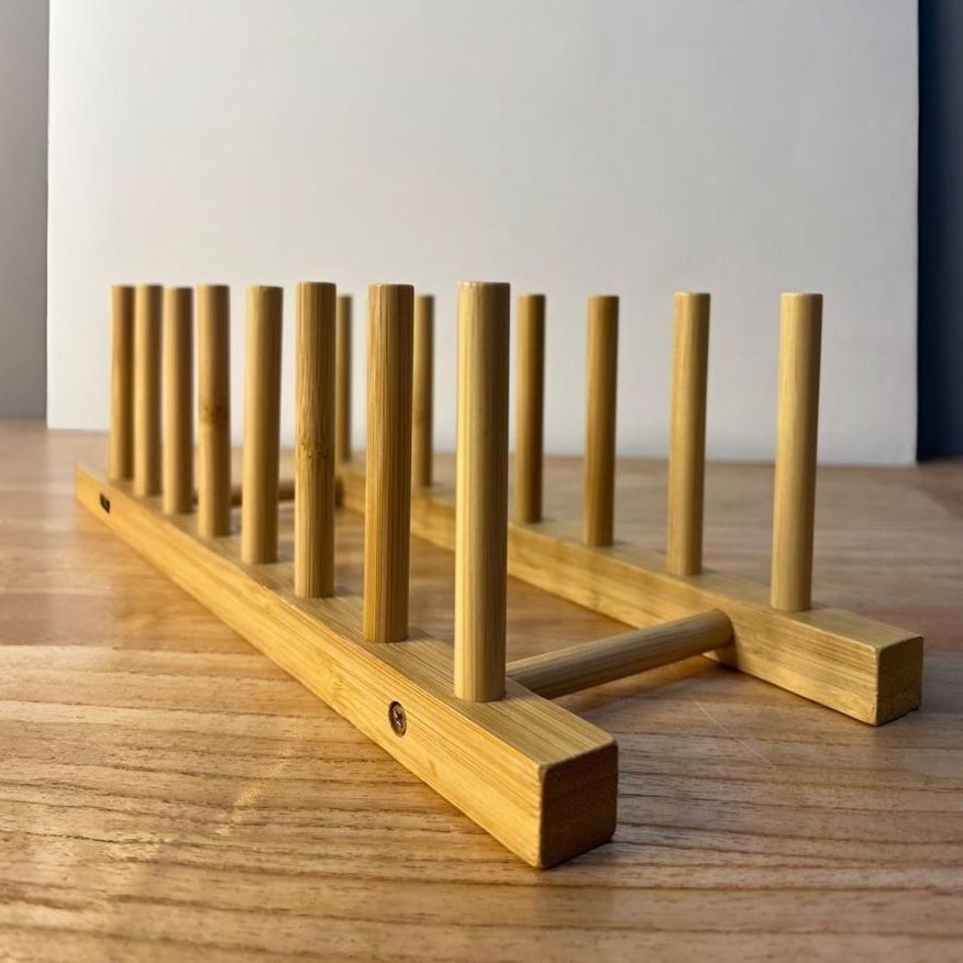 Un estante para platos de madera está sobre una mesa de madera.