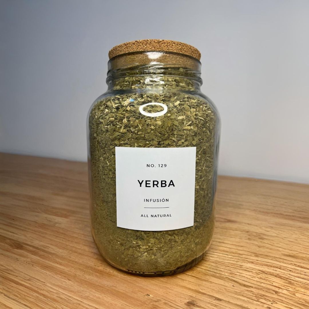 Un frasco de yerba mate está sobre una mesa de madera.