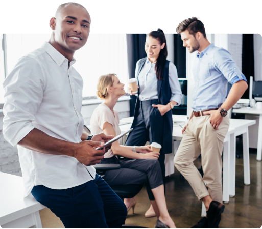 Um grupo de pessoas está em pé ao redor de uma mesa em um escritório.