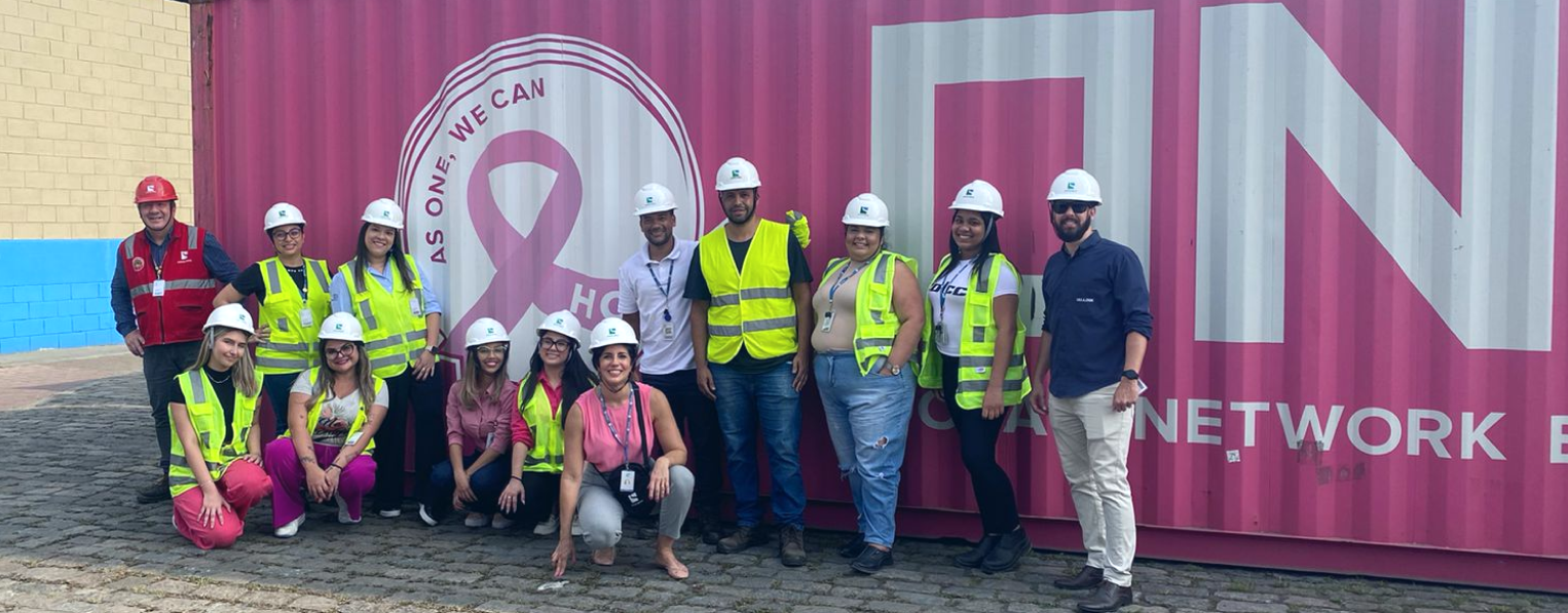 um grupo de pessoas posando para uma foto em frente a um contêiner