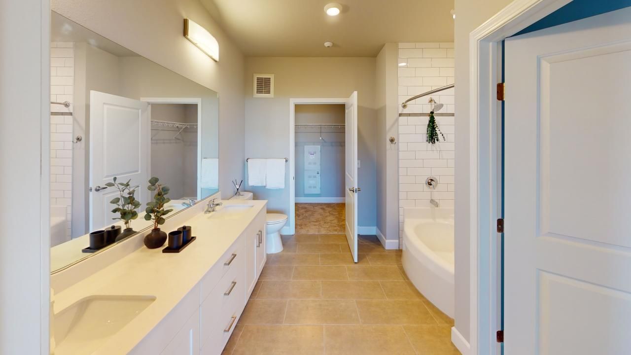 A bathroom with two sinks, a toilet, and a bathtub.