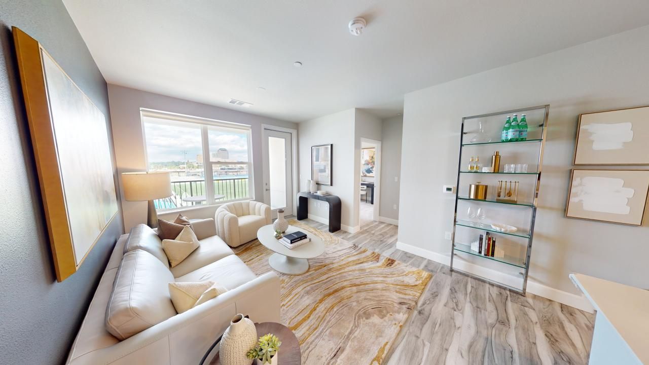 A living room with a couch, chair, coffee table, and shelves.