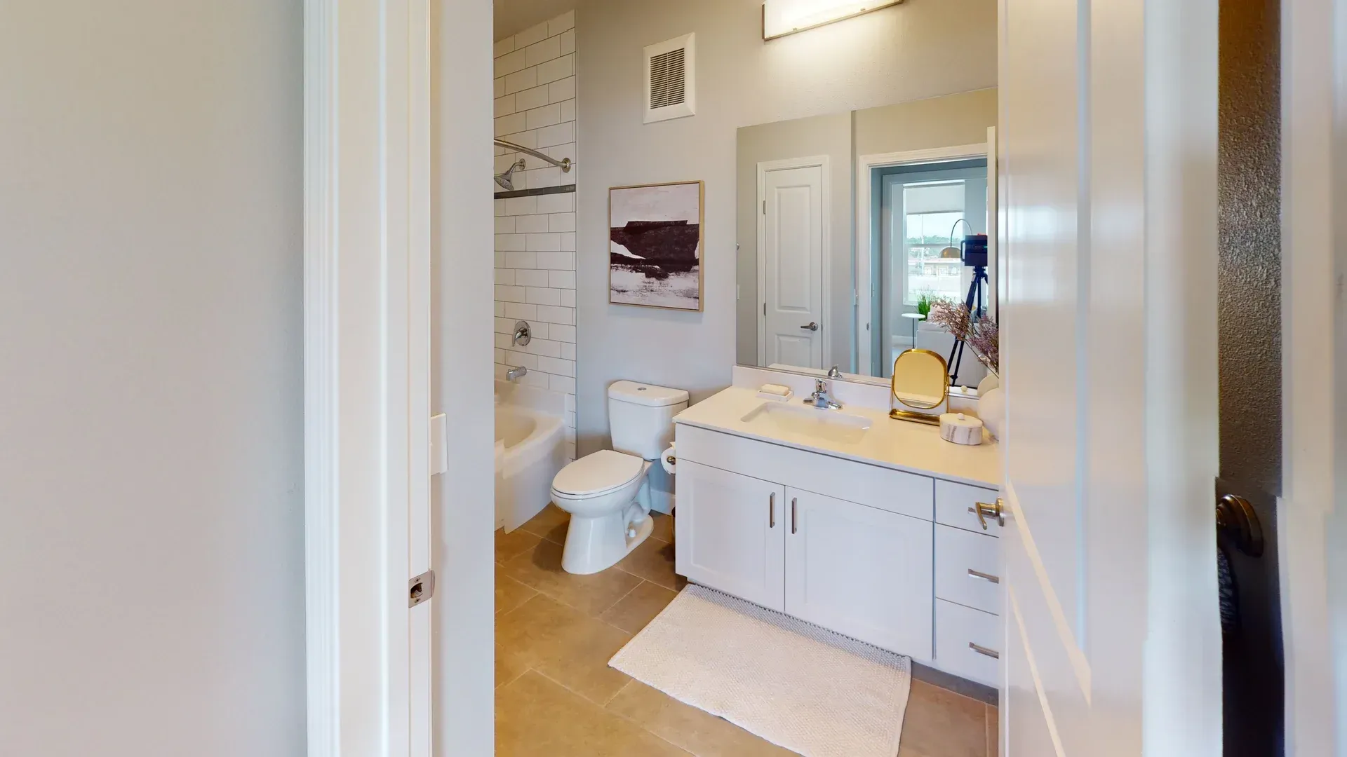 A bathroom with a toilet, sink, and mirror.