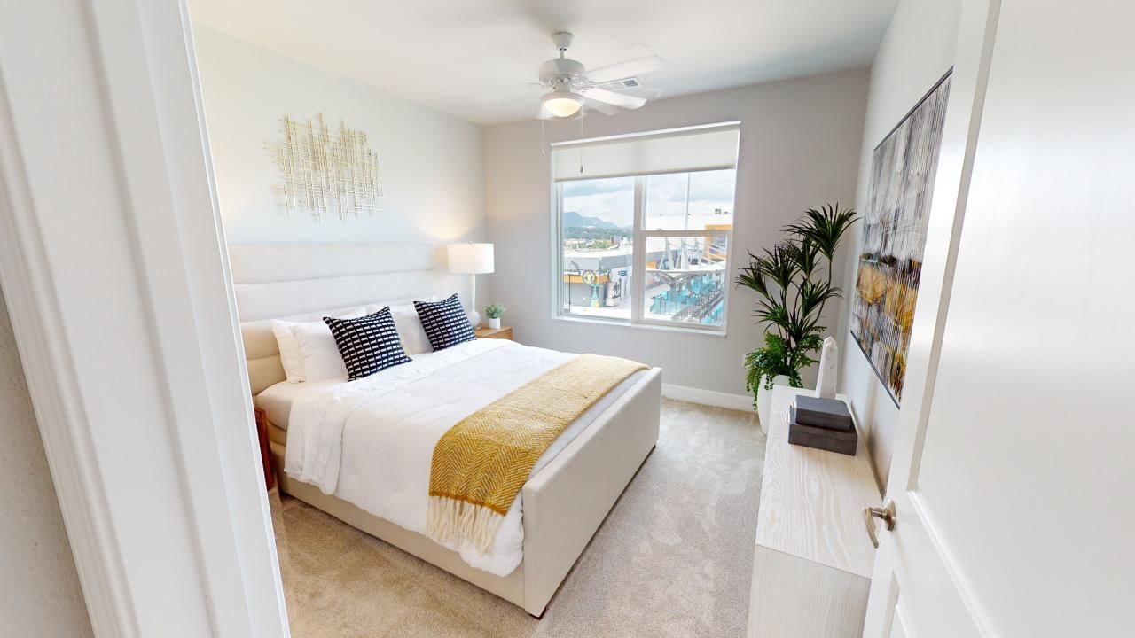 A bedroom with a king size bed and a ceiling fan.