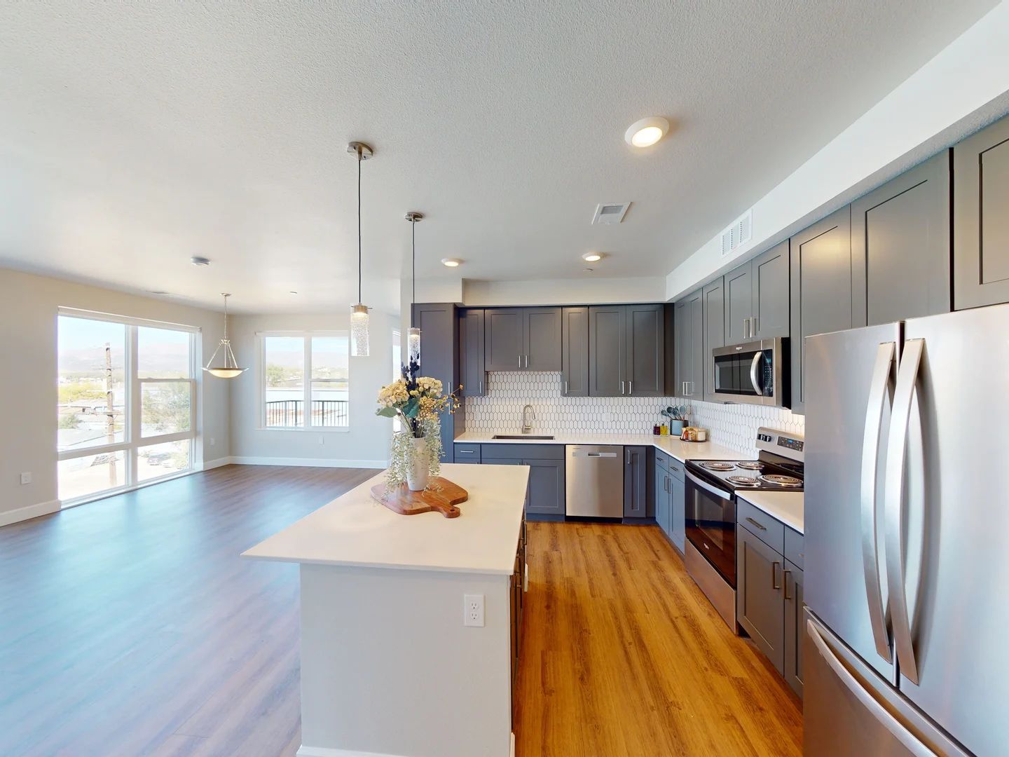 A kitchen with stainless steel appliances and gray cabinets