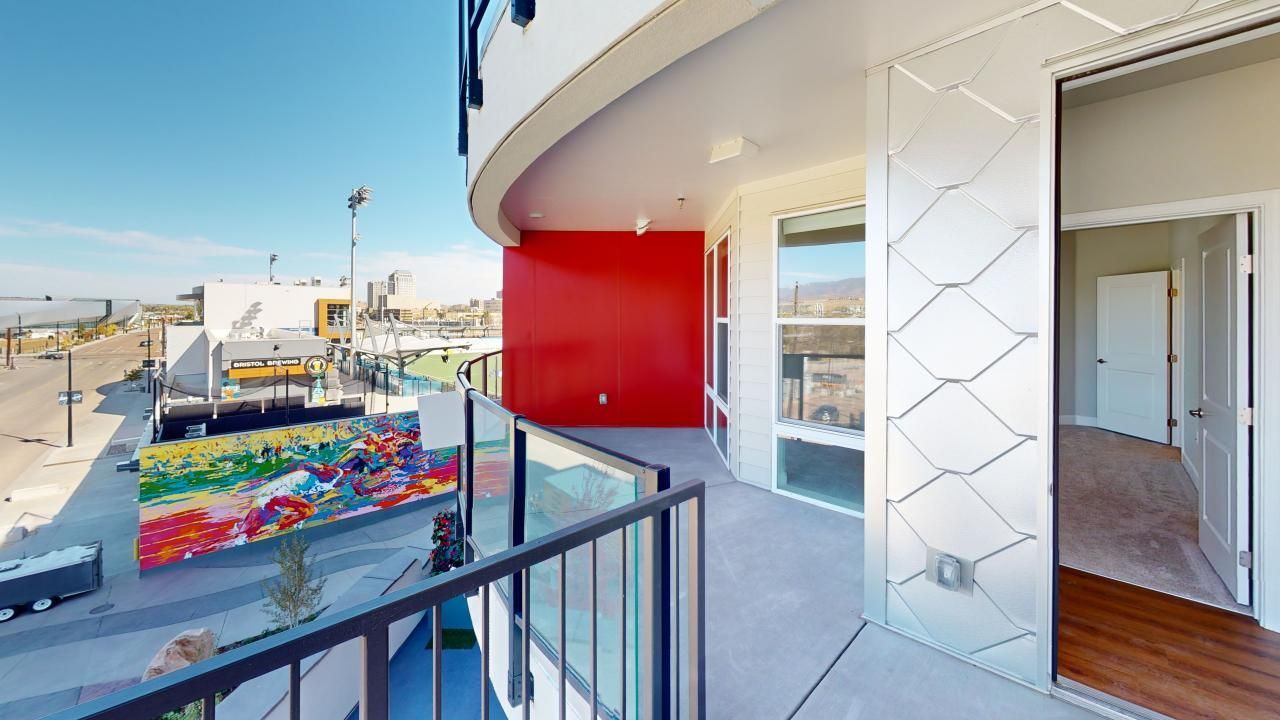 A balcony with a red wall and a painting on it.