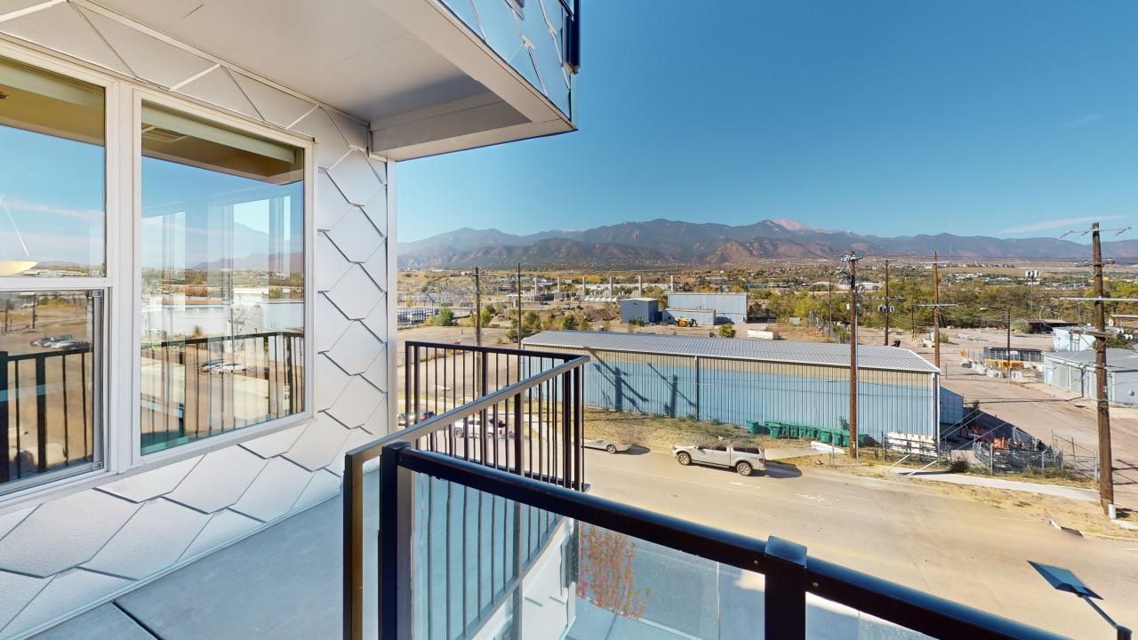 A balcony with a view of a city and mountains.