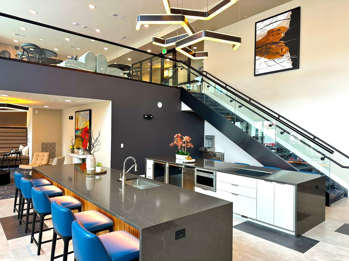A kitchen with a large island and stairs leading up to the second floor.