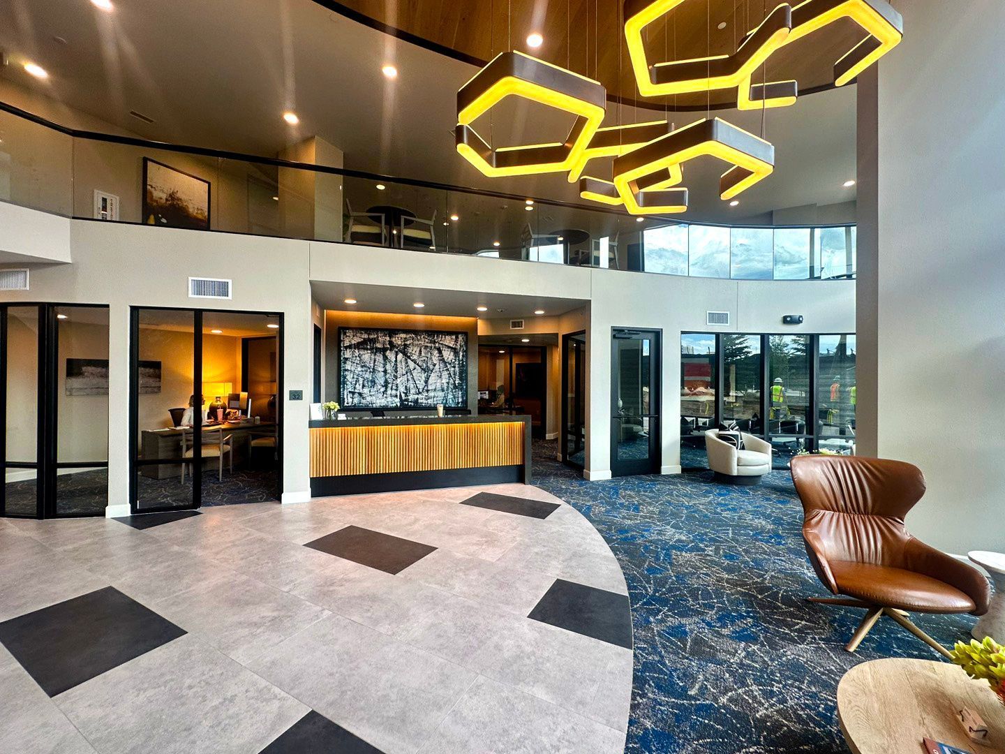 A large lobby of a hotel with a reception desk and chairs.