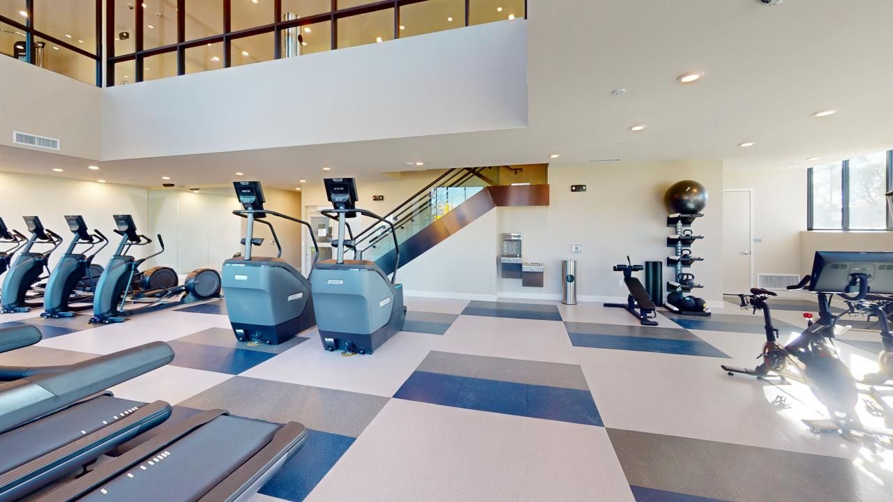 A large gym with a lot of treadmills and exercise bikes.