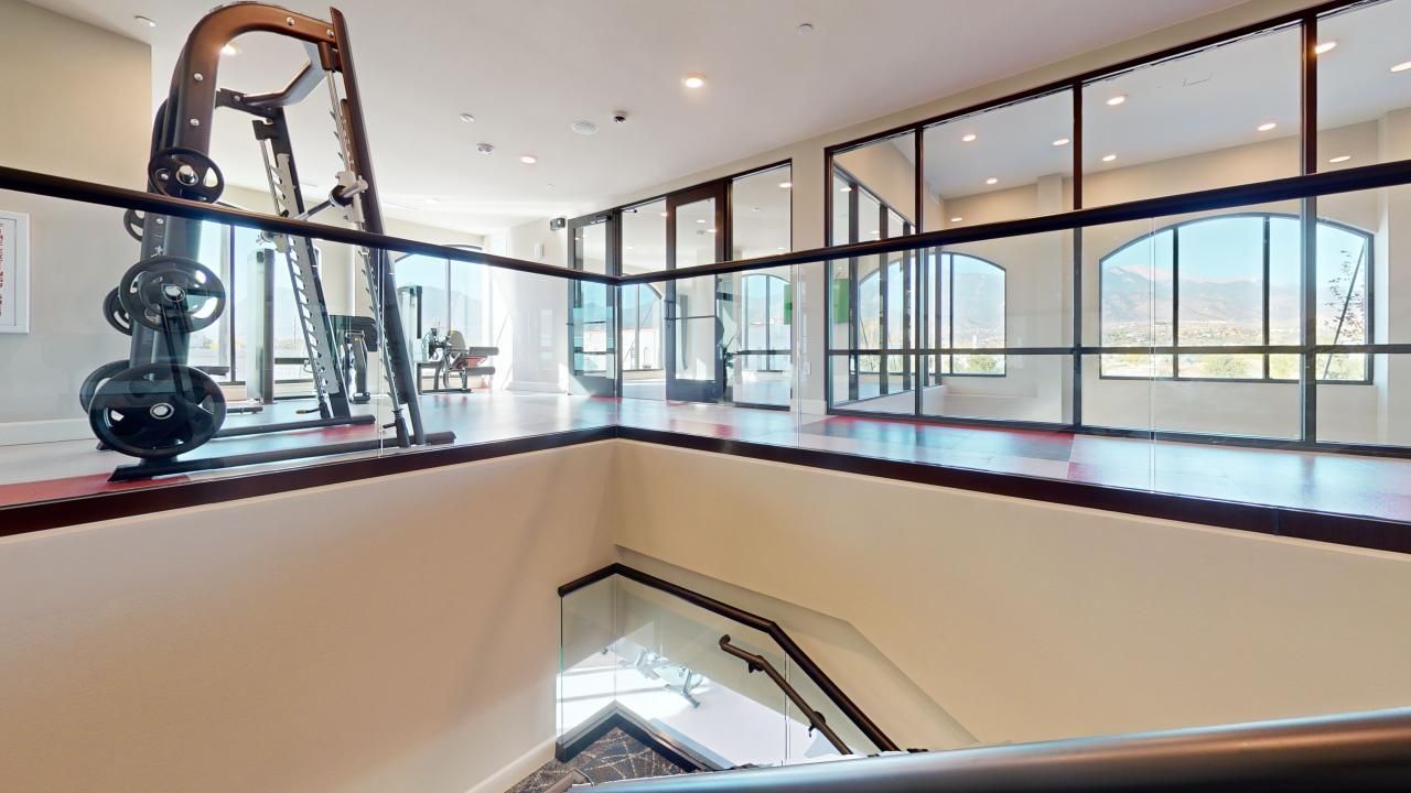 A staircase leading up to a gym in a building with a lot of windows.