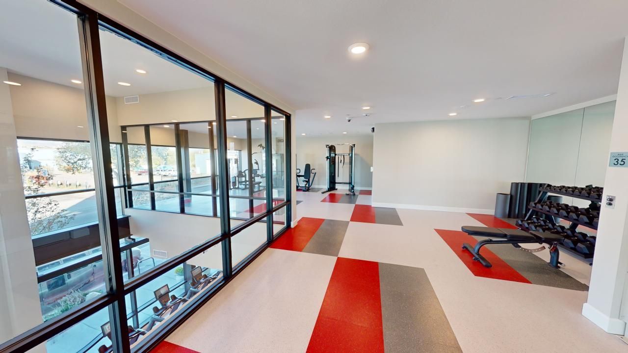 A gym with a lot of windows and a bench.