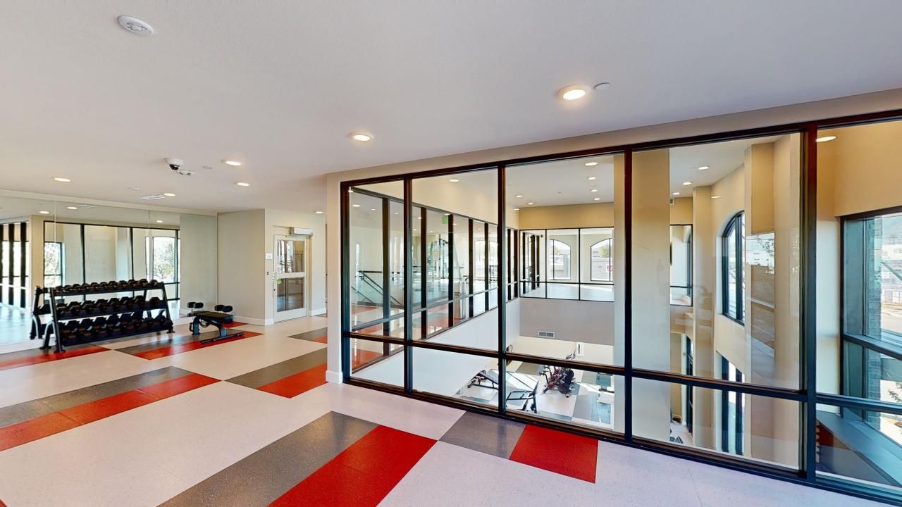 A large room with a lot of windows and a gym in the background.