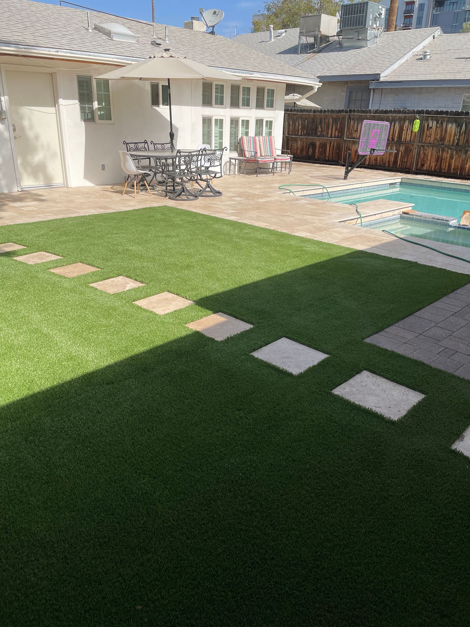There is a swimming pool in the backyard of a house.